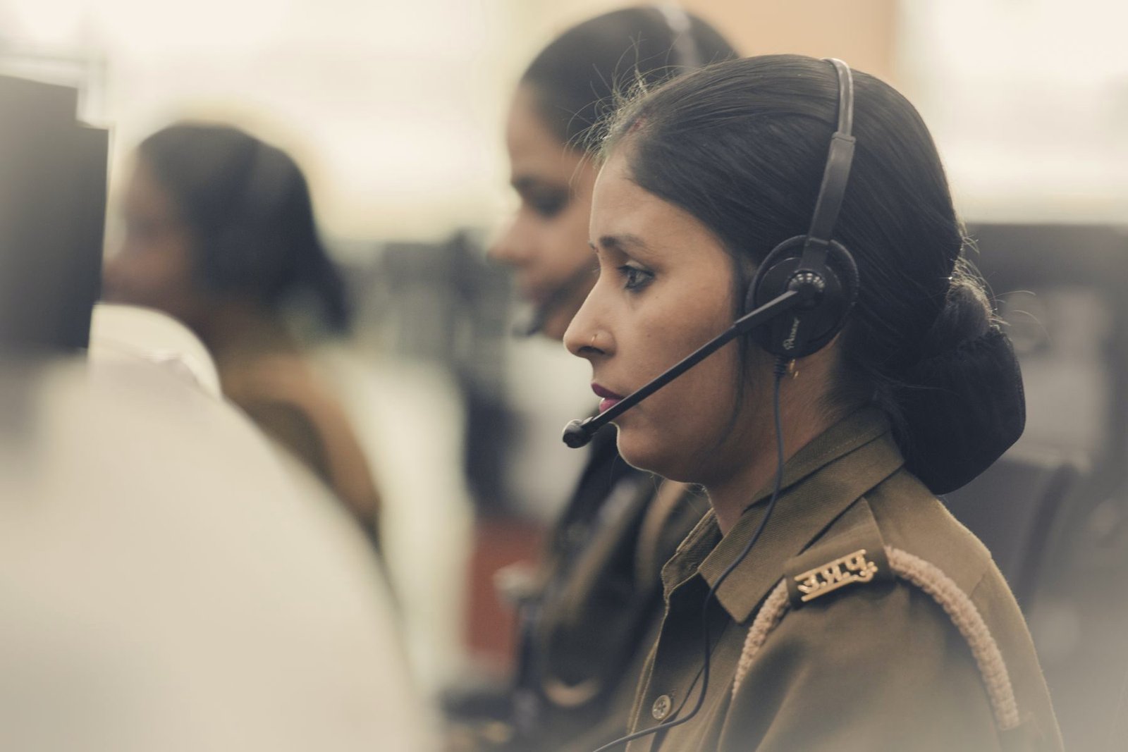 A dispatcher at a desk coordinating a call through a headset.